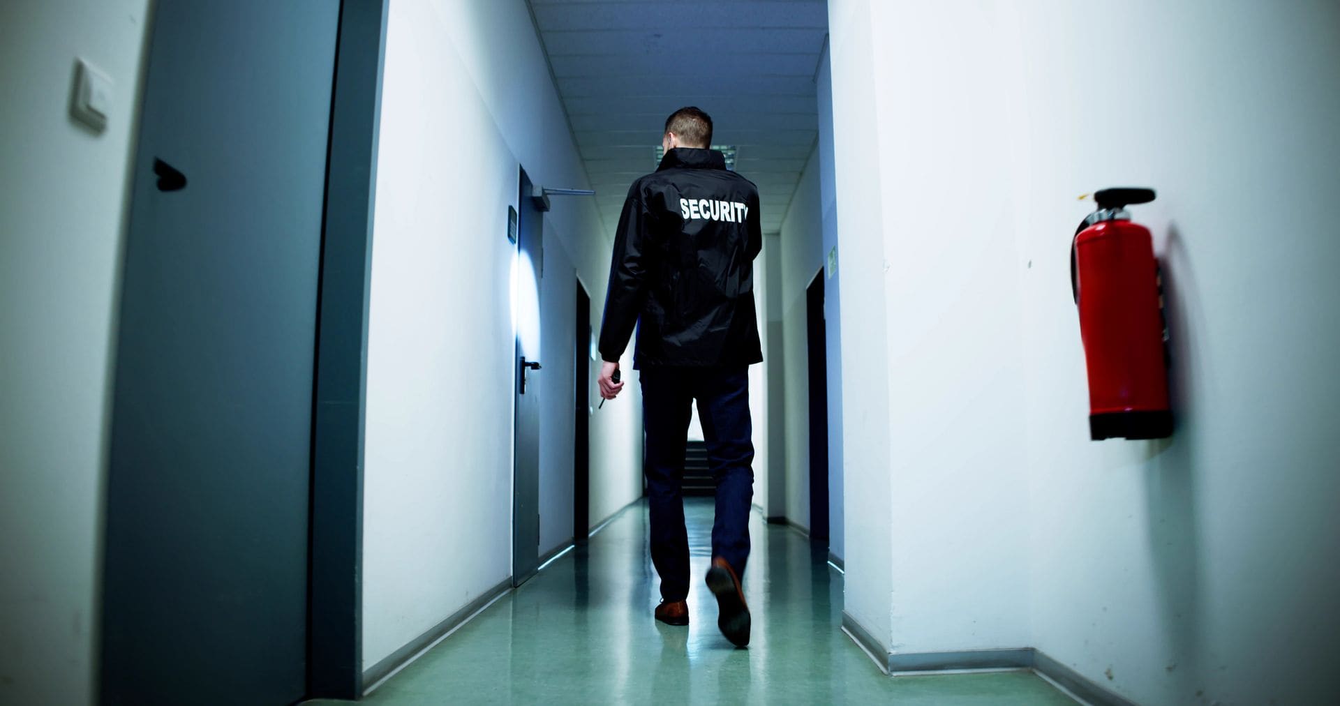 Security guard patrolling a lit corridor