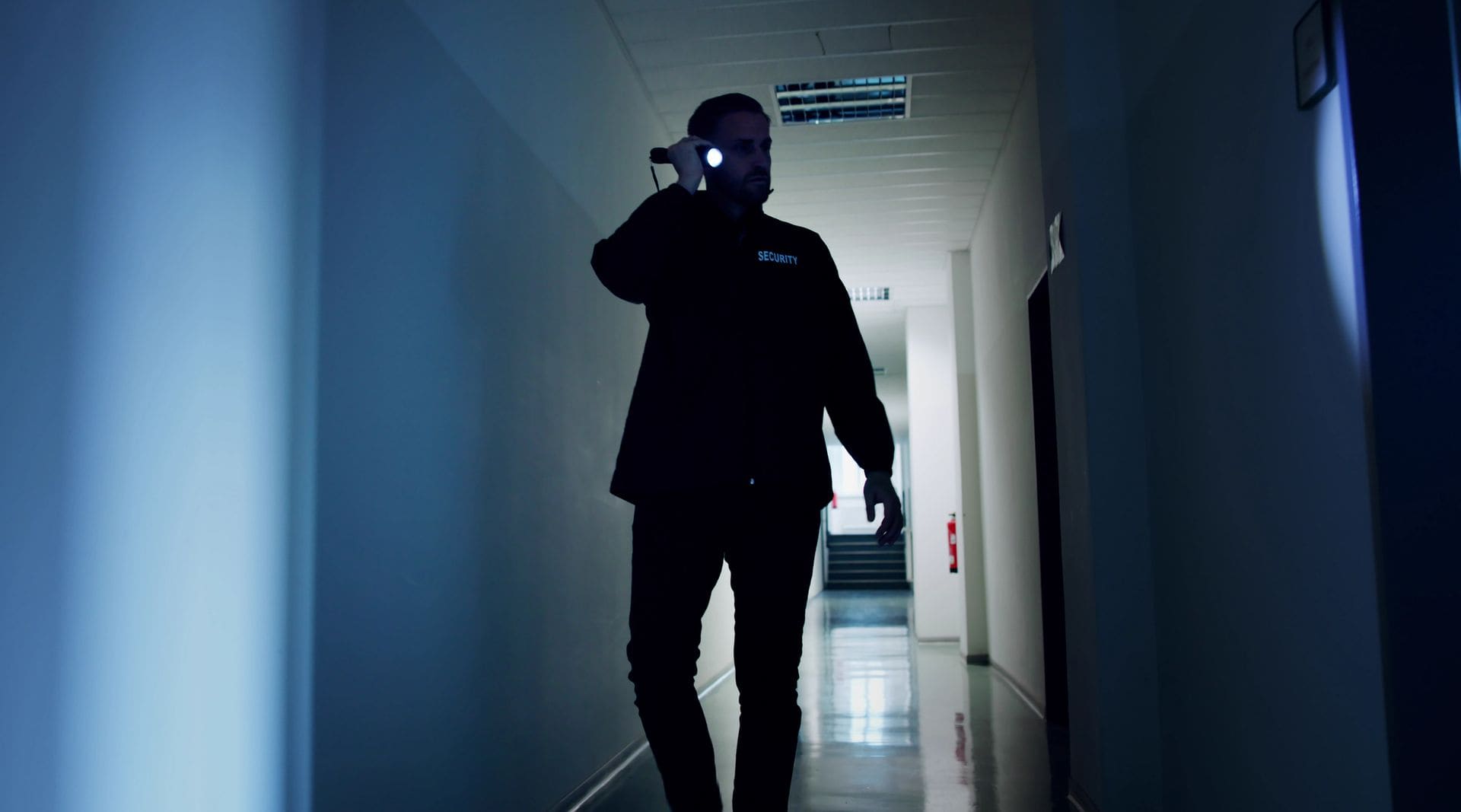 Security guard conducting a night patrol with a flashlight