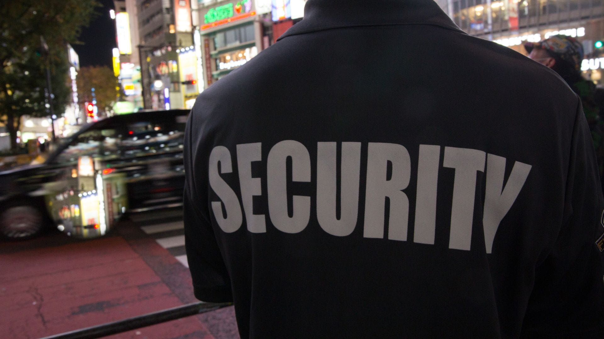 Security guard on night patrol in a city street